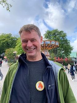 A happy Max at Liseberg with a fairground attraction in the background.